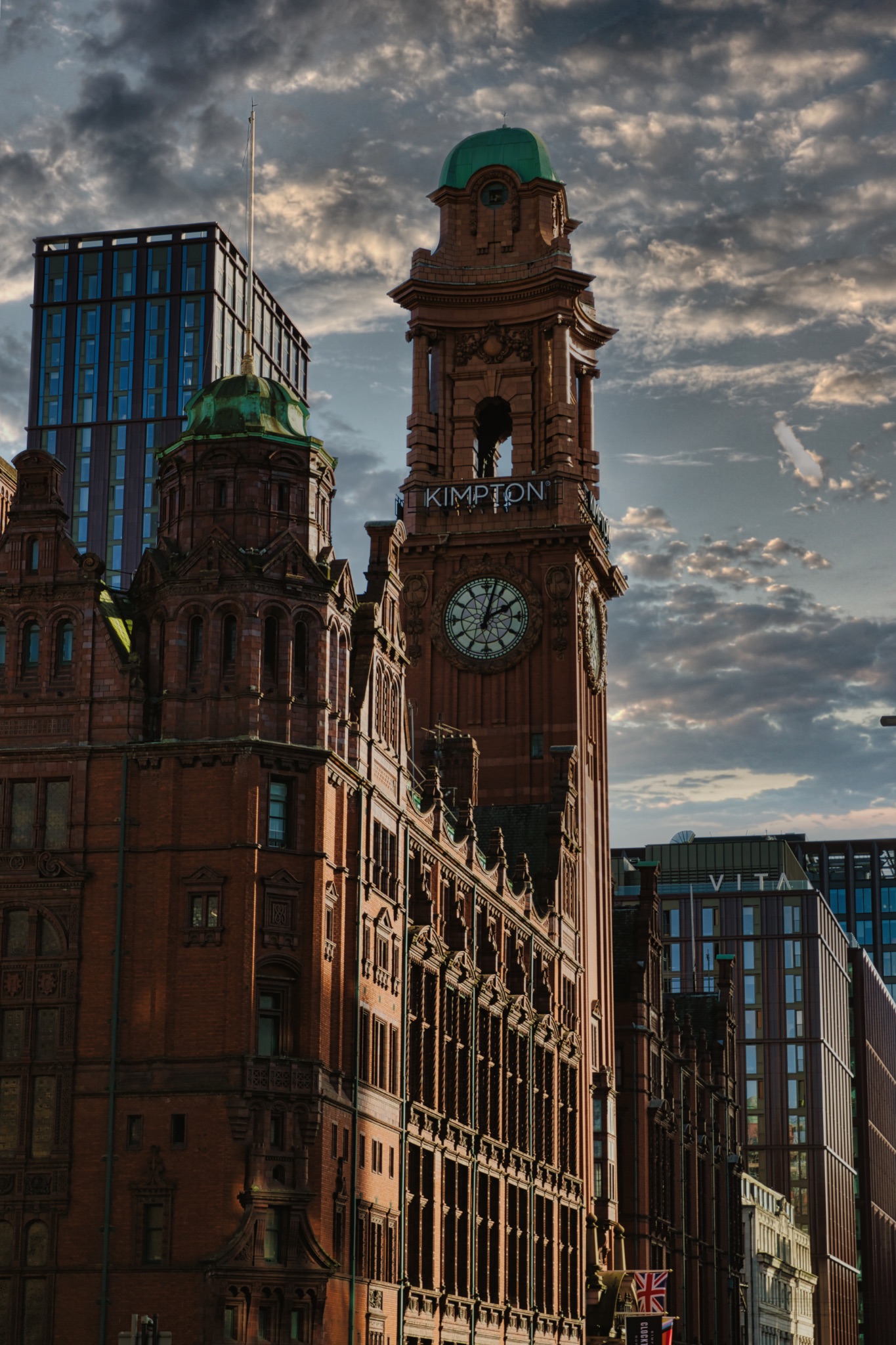Brick Building with Clock Tower and Modern Skyscraper in Manchester, UK.